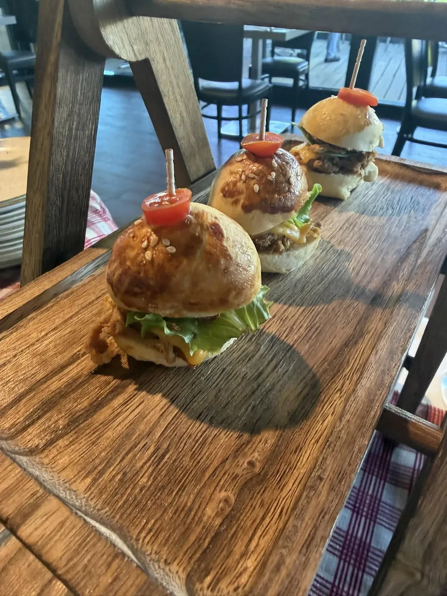 Trois mini-burgers sur une planche en bois